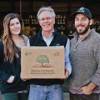 Older man holding Sierra Orchards box with daughter and son